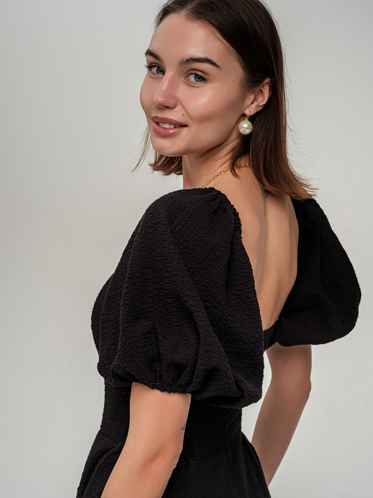 Melna vidēja garuma kleita ar kuplām piedurknēm